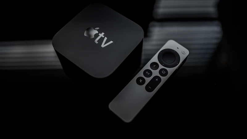 Apple TV Box mit Fernbedienung auf dunklem Hintergrund